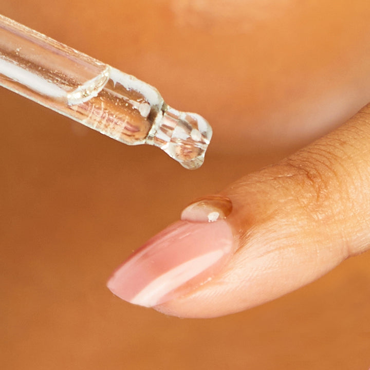 women applying serum on her finger 